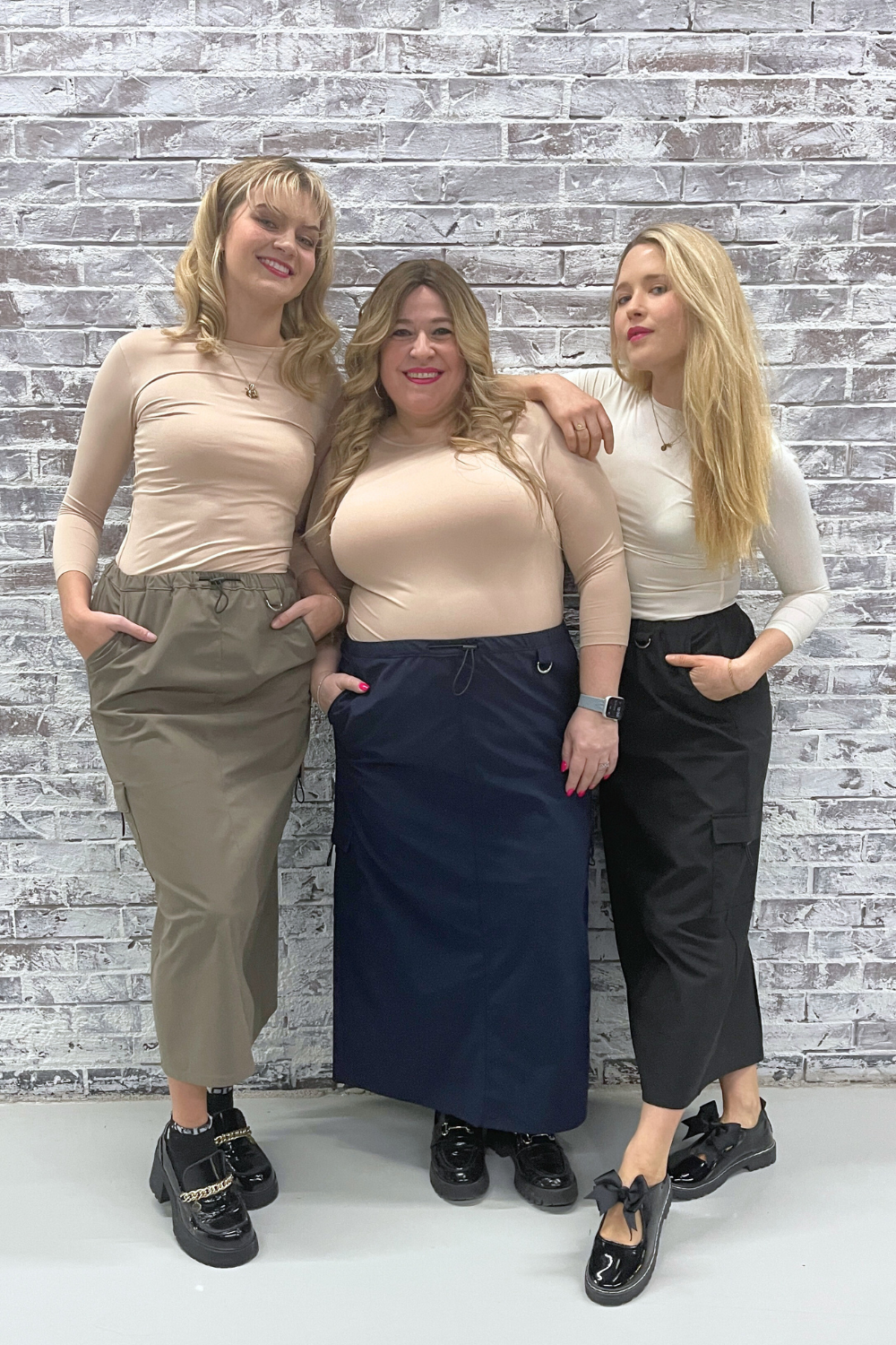 2 thin blonde women wearing long cargo skirts and 1 curvy woman wearing a modest navy blue cargo skirt